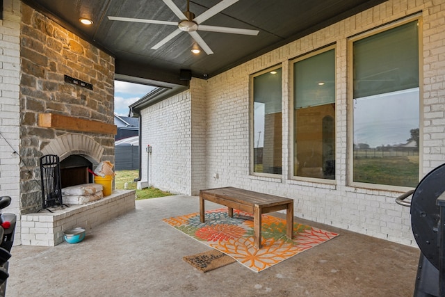 view of patio featuring ceiling fan and an outdoor stone fireplace