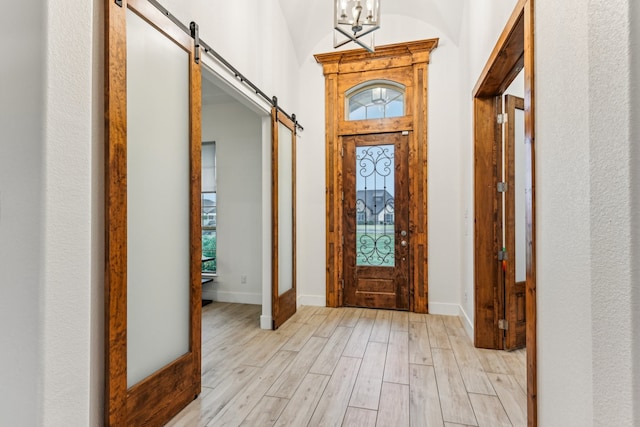 foyer with a barn door and light wood-type flooring