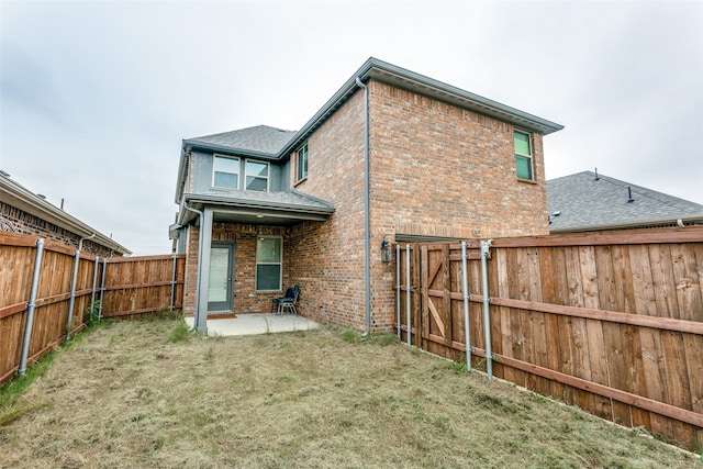 rear view of property featuring a patio area and a yard