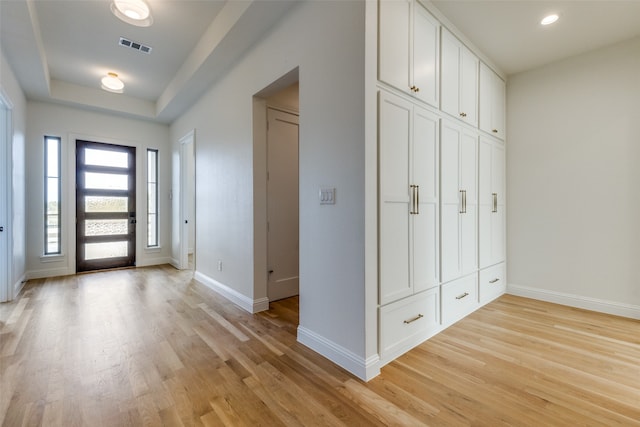 kitchen with premium range hood, light wood-type flooring, appliances with stainless steel finishes, hanging light fixtures, and sink