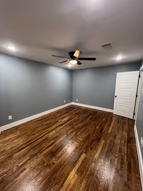 spare room with dark hardwood / wood-style flooring and ceiling fan