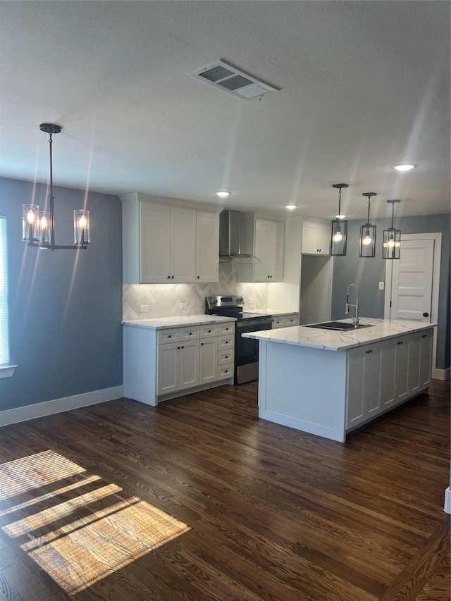 kitchen featuring wall chimney exhaust hood, stainless steel electric range oven, sink, a notable chandelier, and white cabinetry