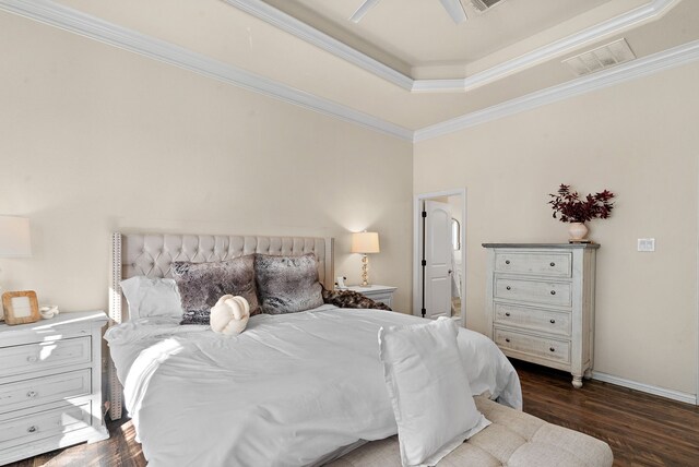 bedroom featuring ceiling fan, a tray ceiling, ornamental molding, and dark hardwood / wood-style floors