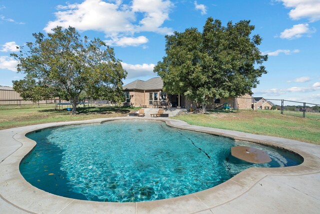 view of swimming pool featuring a lawn