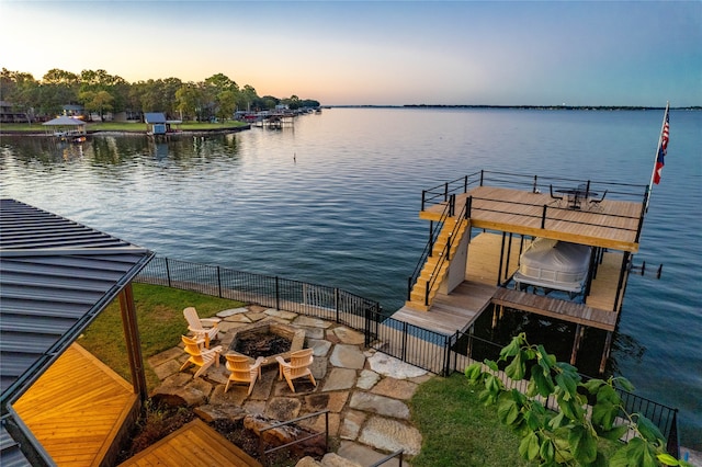 dock area with a water view and a fire pit