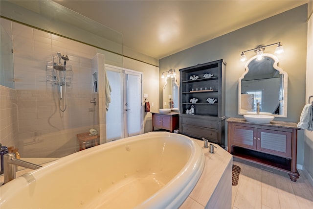 bathroom with vanity and shower with separate bathtub