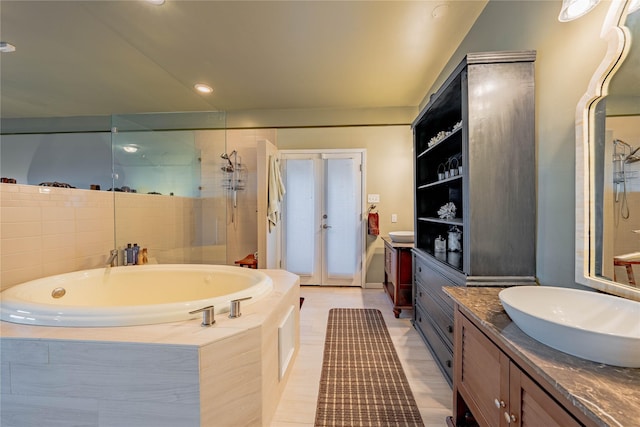 bathroom featuring french doors, tiled shower, a bath, vanity, and recessed lighting