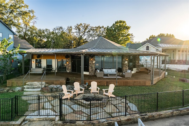 back of property featuring an outdoor living space with a fire pit, a yard, and a deck