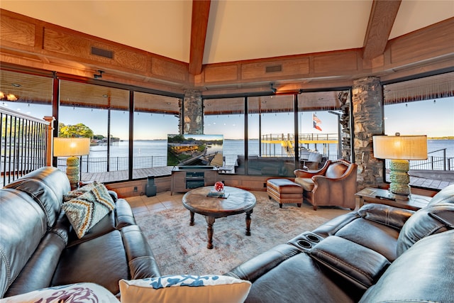 tiled living room featuring wood walls, a towering ceiling, beam ceiling, and a healthy amount of sunlight