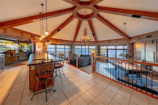 dining area featuring a wealth of natural light, beamed ceiling, and a water view