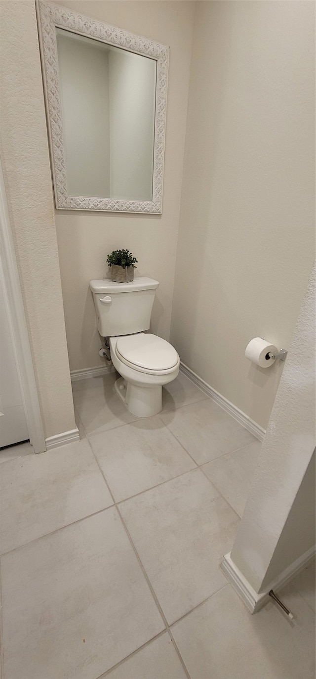 bathroom with toilet and tile patterned flooring