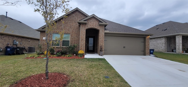 view of front of house with a front yard, a garage, and central air condition unit