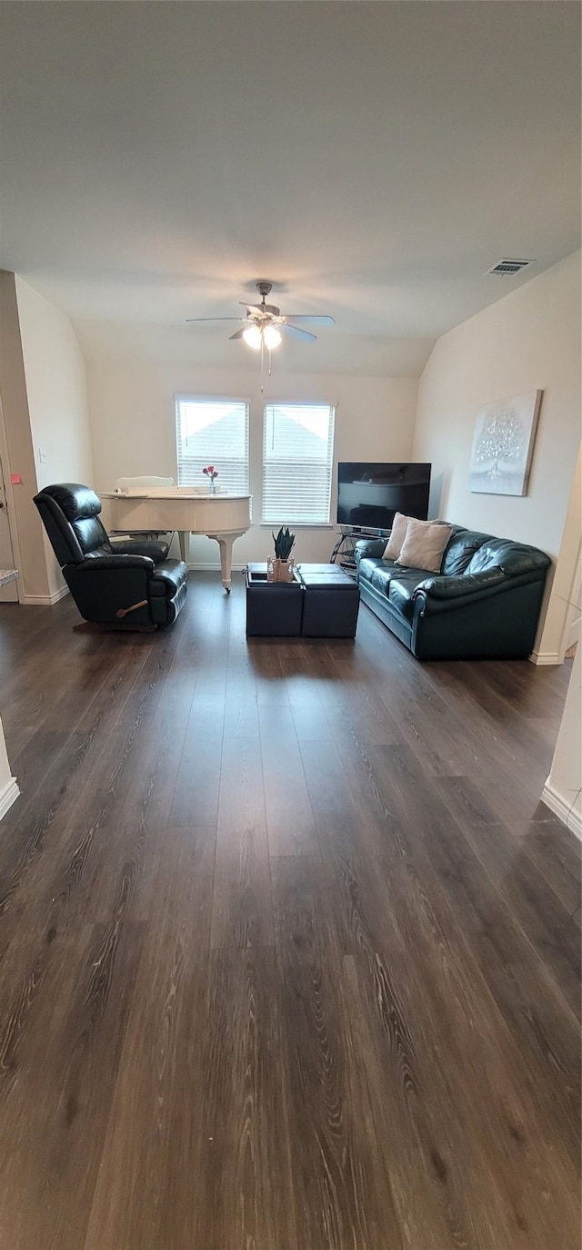 living room with dark wood-type flooring, ceiling fan, and lofted ceiling