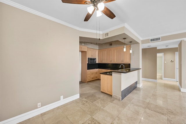 kitchen featuring stainless steel microwave, dark countertops, light brown cabinets, and visible vents