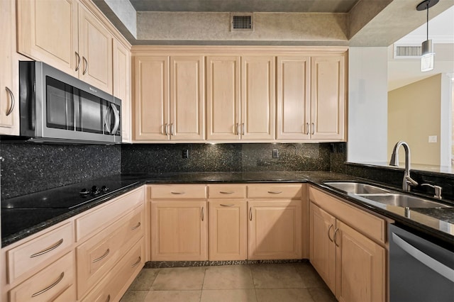 kitchen featuring light tile patterned floors, light brown cabinets, stainless steel appliances, a sink, and visible vents