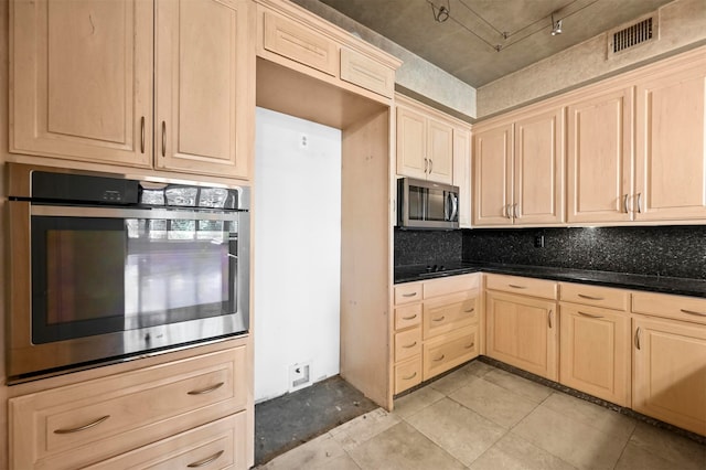 kitchen with light tile patterned floors, stainless steel appliances, visible vents, decorative backsplash, and light brown cabinetry