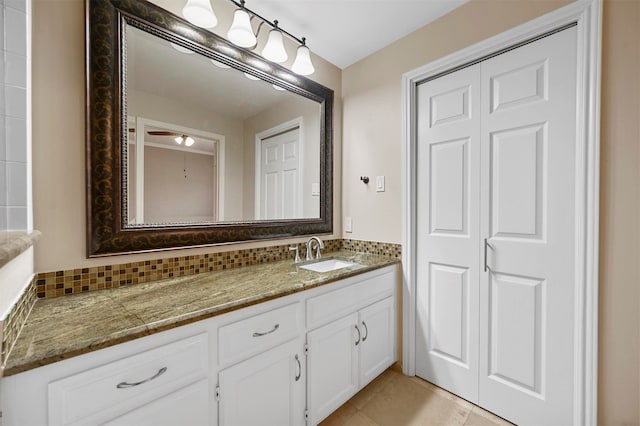 bathroom featuring ceiling fan, tile patterned flooring, vanity, and tasteful backsplash