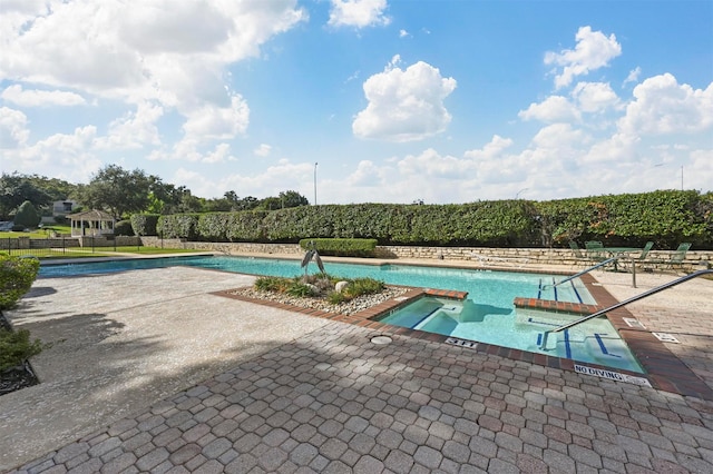 view of pool with a patio area and a hot tub