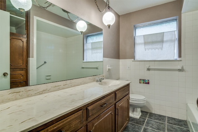 full bathroom with toilet, vanity, tile patterned floors, and tile walls