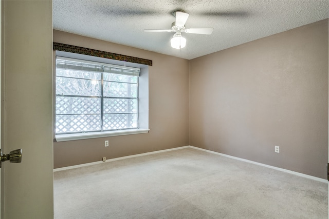 unfurnished room featuring a textured ceiling, light colored carpet, and ceiling fan