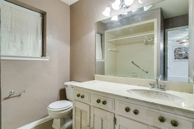 bathroom featuring vanity, toilet, a textured ceiling, and walk in shower