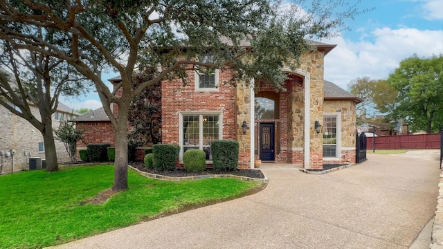 view of front of property featuring a front lawn and central AC