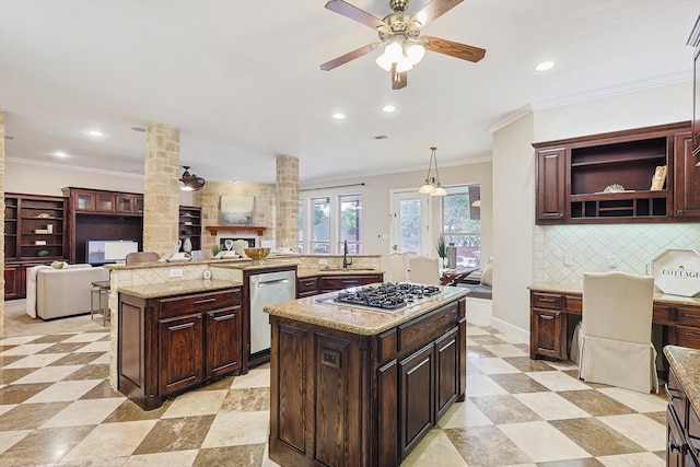 kitchen featuring decorative columns, appliances with stainless steel finishes, decorative light fixtures, and a kitchen island