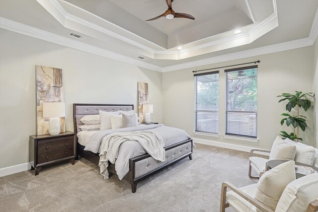 bedroom with ceiling fan, crown molding, a tray ceiling, and light colored carpet