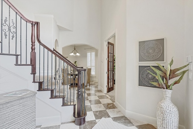 entryway featuring a towering ceiling and a chandelier