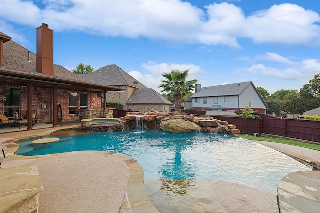 view of swimming pool with a patio, pool water feature, and an in ground hot tub