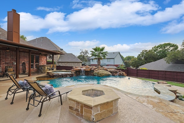 view of pool featuring an in ground hot tub, pool water feature, and a patio area