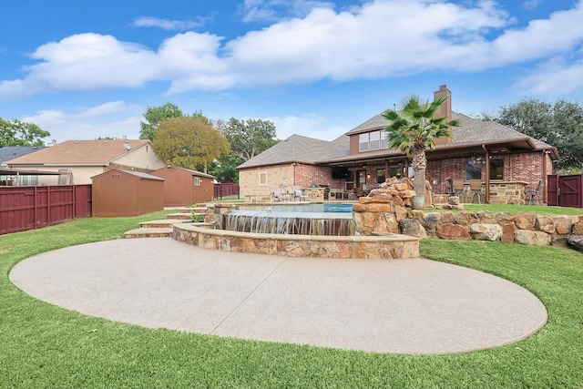 back of house with a patio, a storage shed, a fenced in pool, and a yard