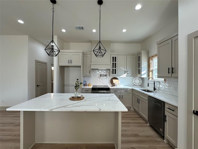 kitchen with black dishwasher, sink, hanging light fixtures, a center island, and stainless steel range oven