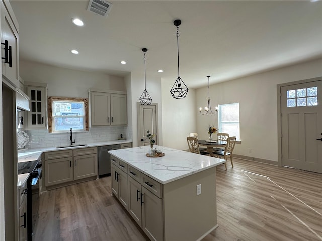 kitchen featuring pendant lighting, sink, a center island, stainless steel dishwasher, and electric range