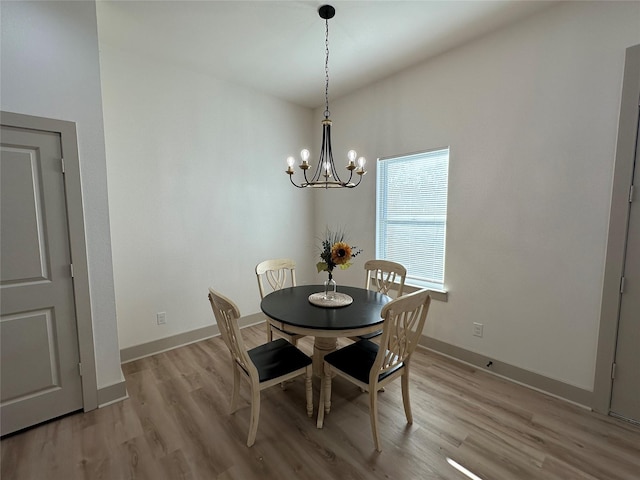 dining space featuring light hardwood / wood-style flooring and a notable chandelier