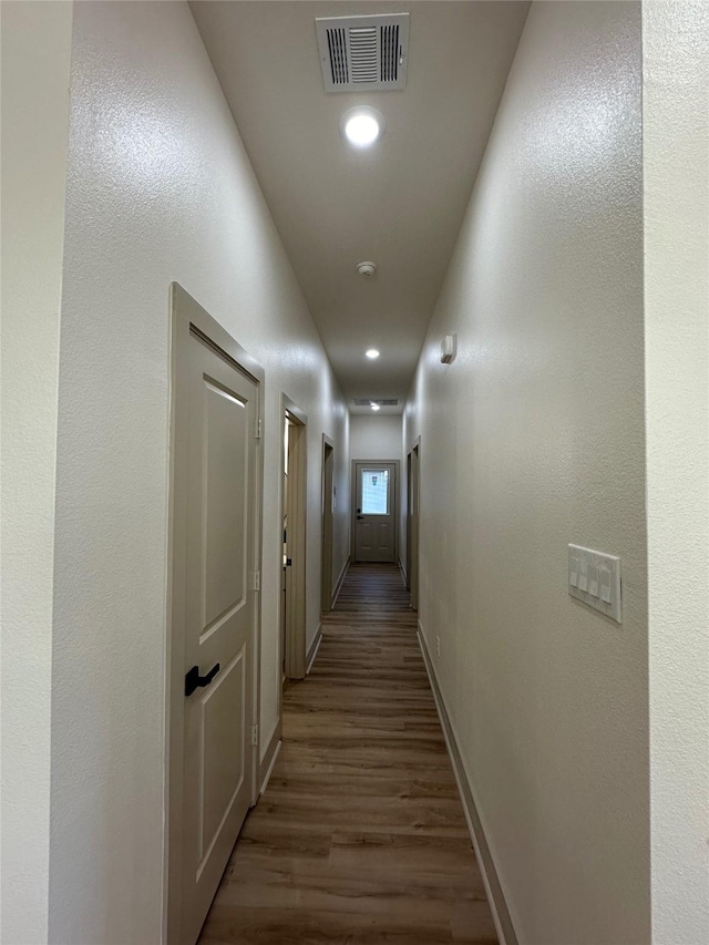 corridor with hardwood / wood-style flooring