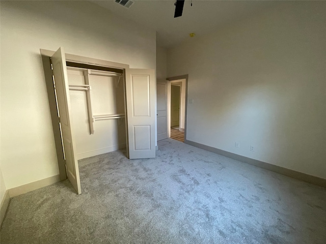 unfurnished bedroom with ceiling fan, a closet, and carpet floors