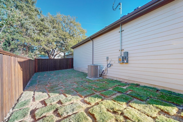 view of side of property featuring a yard and central AC unit