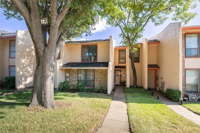 townhome / multi-family property with a front yard