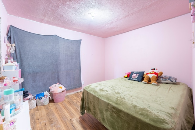 bedroom featuring a textured ceiling and light hardwood / wood-style floors