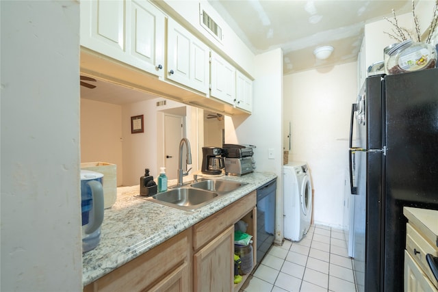 kitchen featuring washing machine and dryer, light tile patterned flooring, black appliances, sink, and light brown cabinets