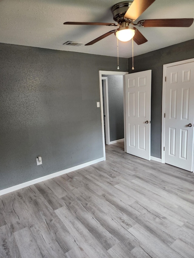 unfurnished bedroom with ceiling fan and light wood-type flooring