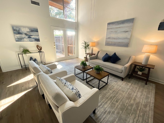 living room with a high ceiling and dark hardwood / wood-style floors