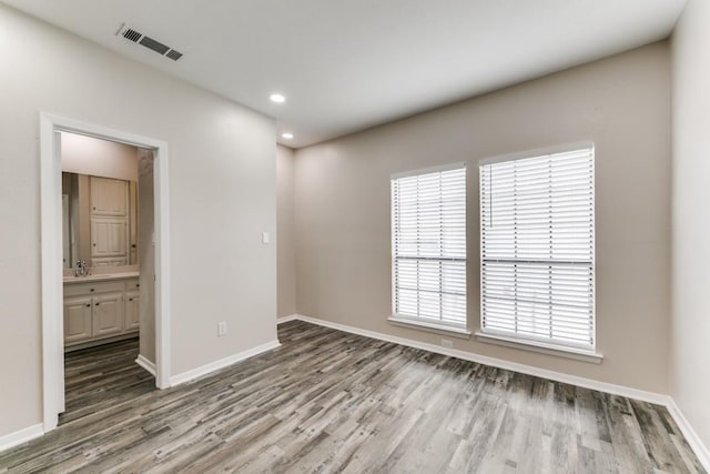 unfurnished room featuring sink and hardwood / wood-style flooring