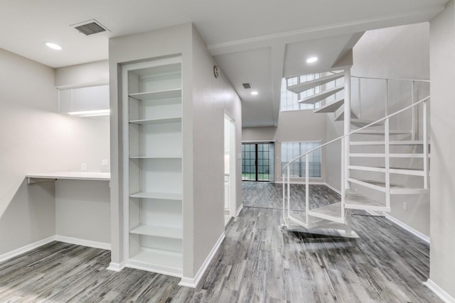 interior space featuring wood-type flooring and built in shelves