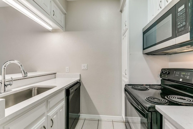 kitchen with sink, light tile patterned floors, white cabinets, and black appliances