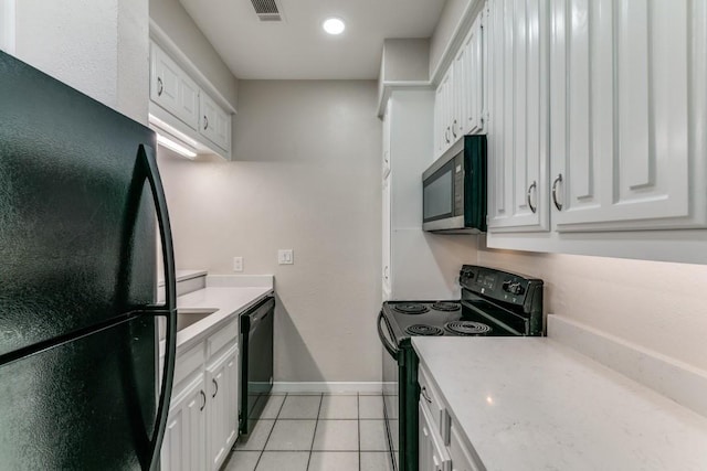 kitchen featuring light tile patterned floors, white cabinets, and black appliances