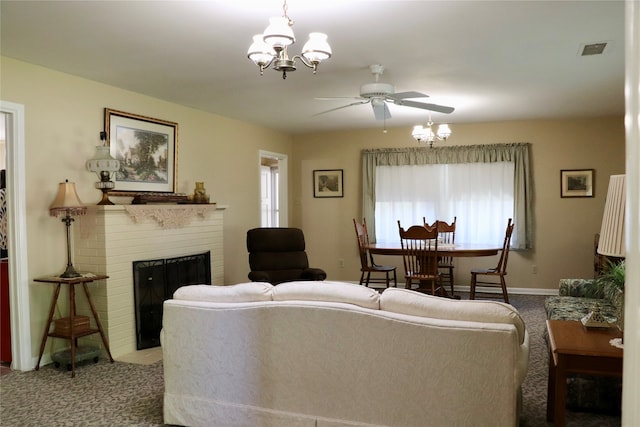 carpeted living room featuring a brick fireplace and ceiling fan with notable chandelier