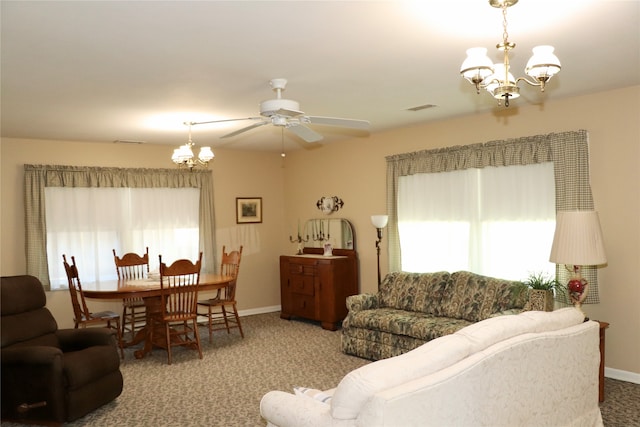 living room with carpet, ceiling fan with notable chandelier, and a healthy amount of sunlight