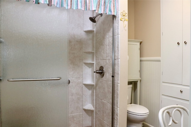 bathroom with toilet, wood walls, and a shower with door